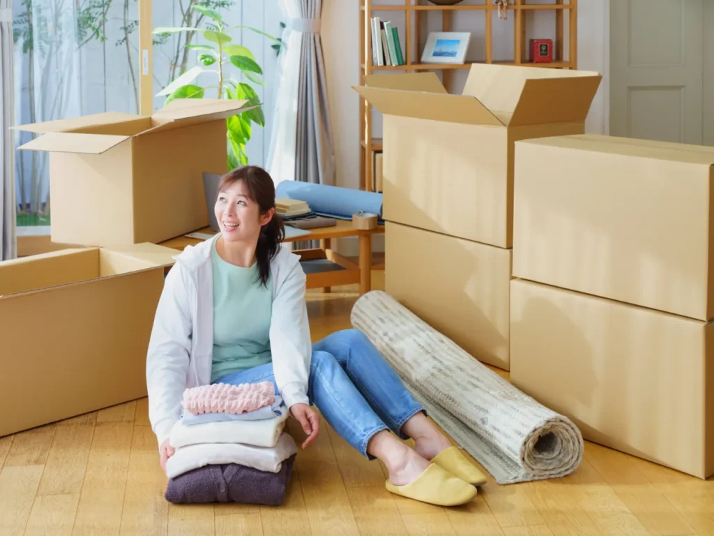 部屋で引っ越しの準備をする女性（イメージ写真）